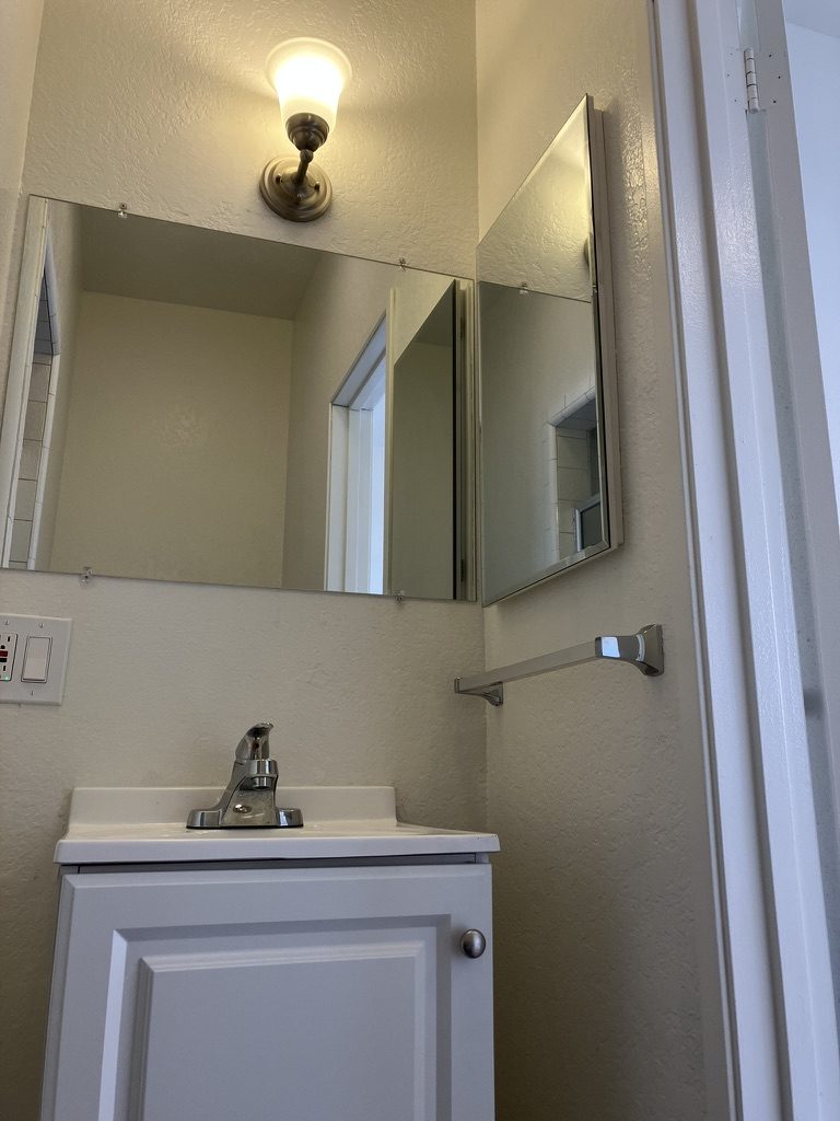 Vanity after — new vanity, mirror, and hardwired light