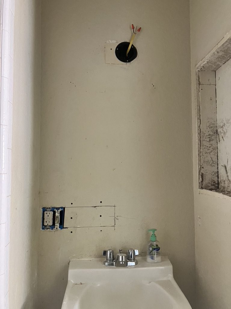 Vanity wall before — open wall and electrical rough-in