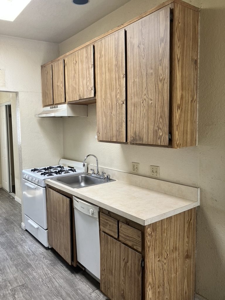 Kitchen before — wood cabinets and dated laminate counters