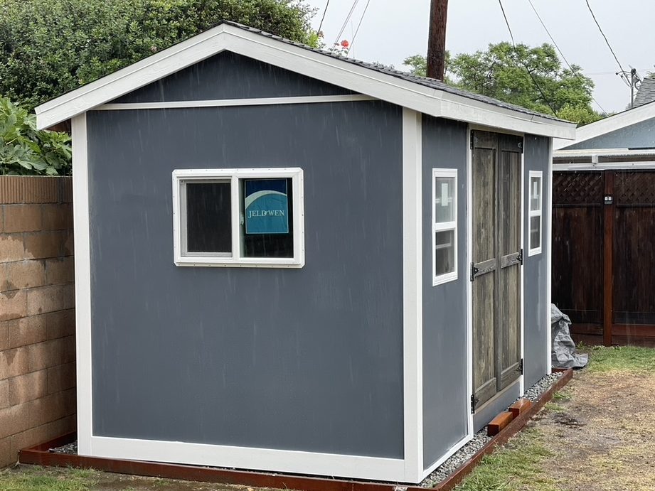 Finished blue-grey shed with white trim and barn doors