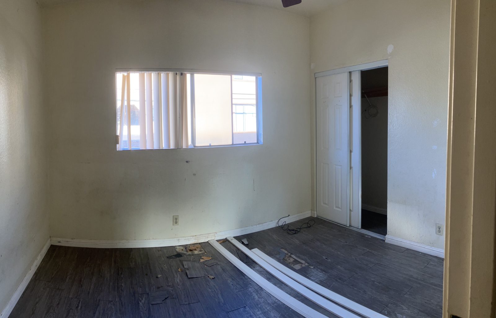 Bedroom before remodel — damaged flooring and worn finishes
